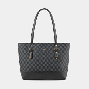 A black and dark gray checkered tote bag with black leather handles and base, featuring gold-tone hardware and a small gold 'GUESS' logo on the front, set against a light gray background.