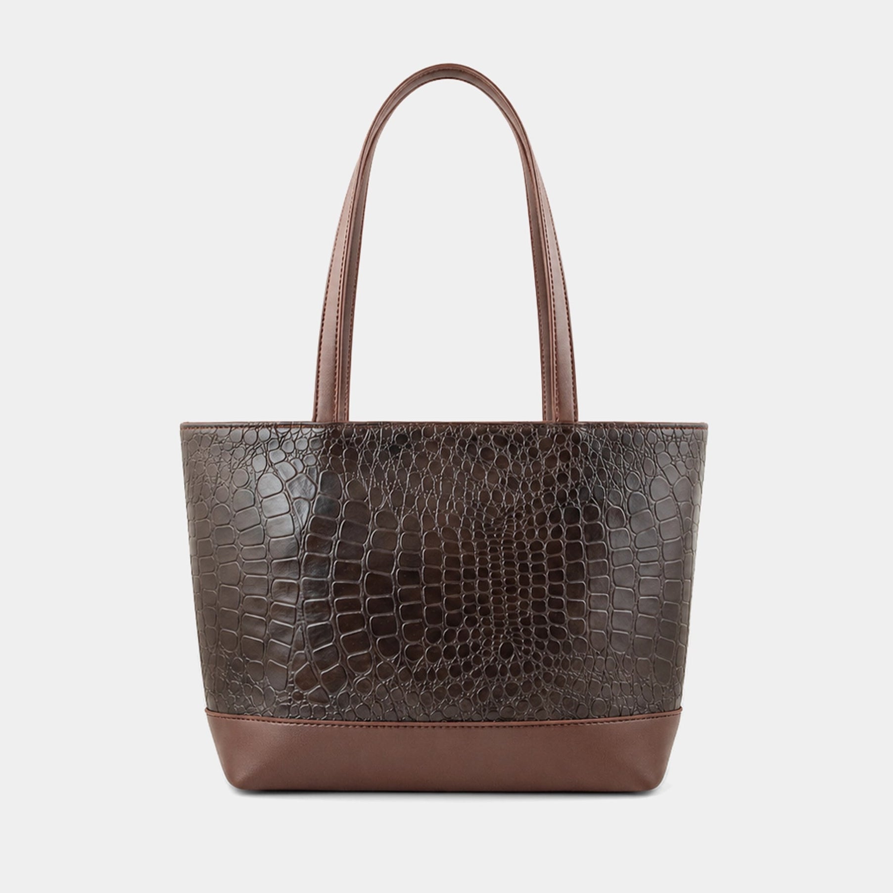A dark brown tote bag with a crocodile-embossed texture on the main body and smooth brown handles and base, shown against a light gray background.