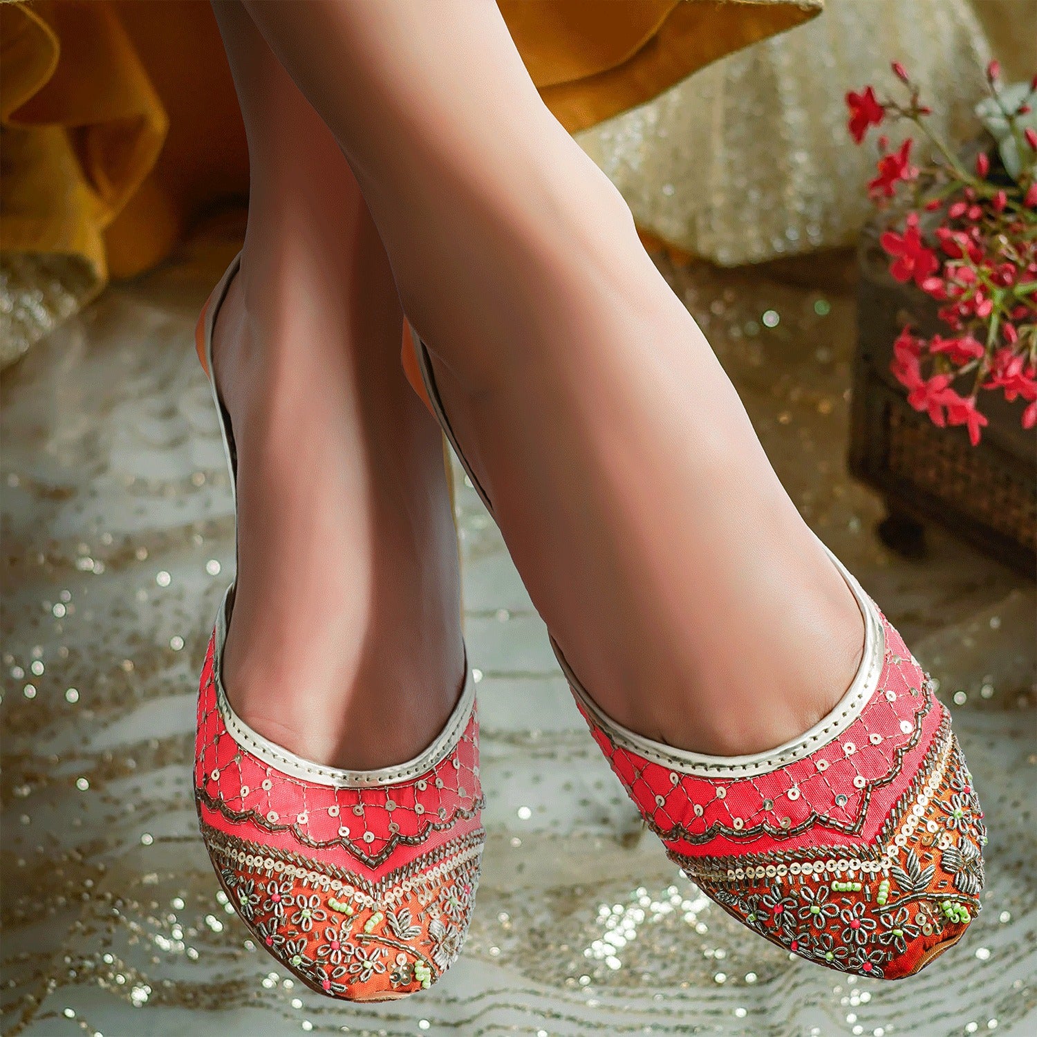 Discover handmade Khussa shoes for women, epitome of tradition with vibrant orange and yellow silk adorned with sequins. Ideal for weddings and events.