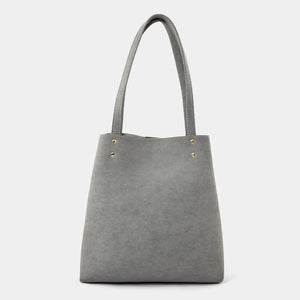 A gray faux-leather tote bag with double shoulder straps and small gold-tone metal rivets near the top, shown against a plain light gray background.