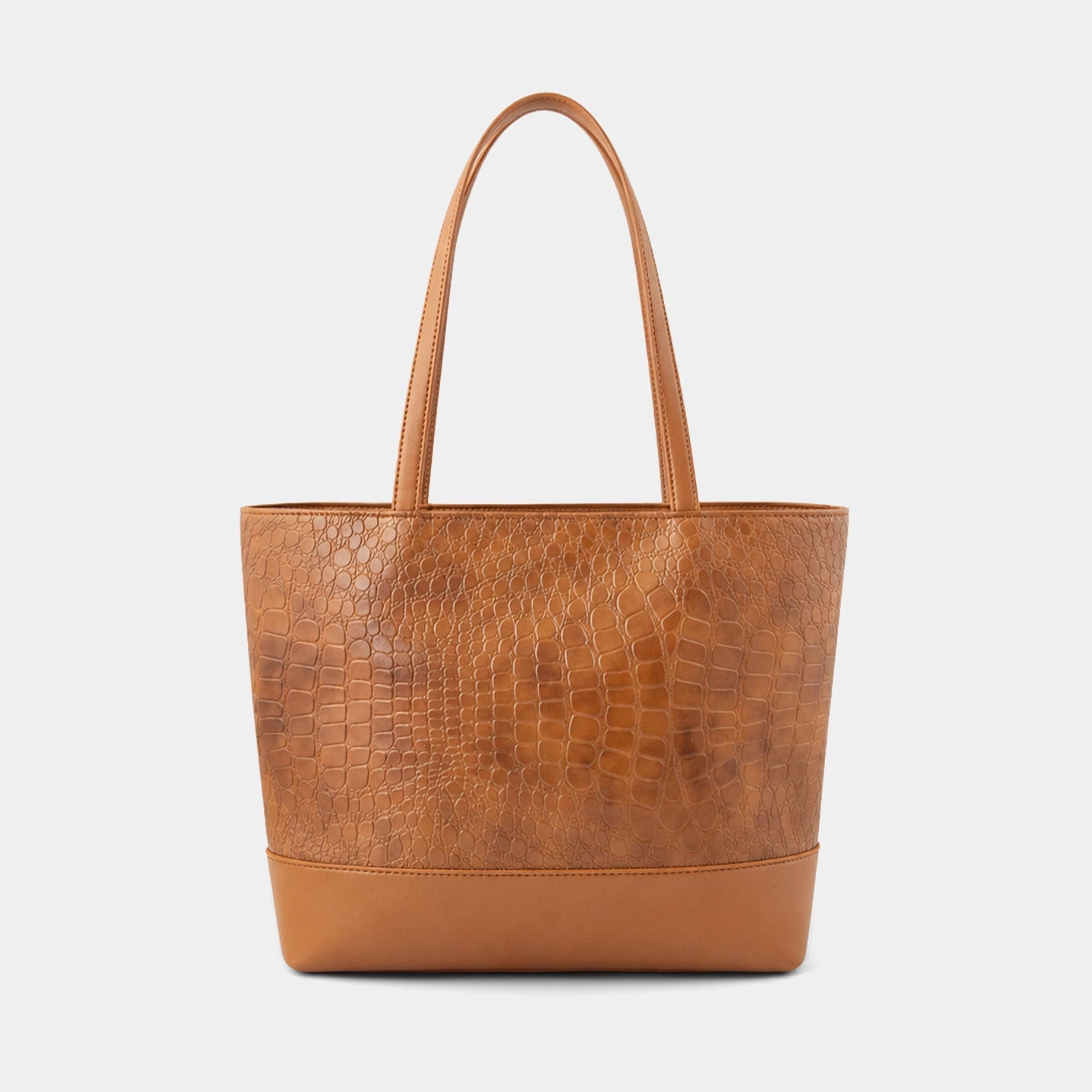 A structured tan leather tote bag with a crocodile-embossed texture on the main body, smooth leather trim and handles, and gold-tone hardware, shown against a light gray background.