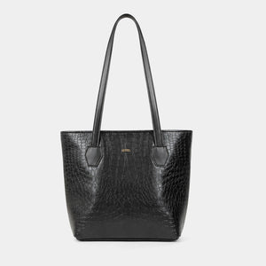 A black crocodile-embossed leather tote bag with dual shoulder straps and a small gold-tone logo plaque on the front, set against a solid light gray background.